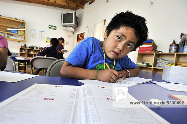 Junge macht seine Mathematik-Hausaufgaben in einer Nachmittagsgruppe  Puebla  Mexiko  Mittelamerika