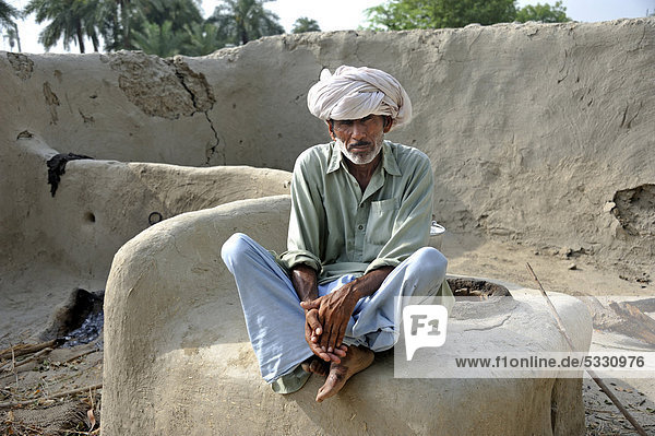 Alter Mann mit Turban sitzt auf einem Brot-Ofen  Dorf Basti Lehar Walla  Punjab  Pakistan  Asien