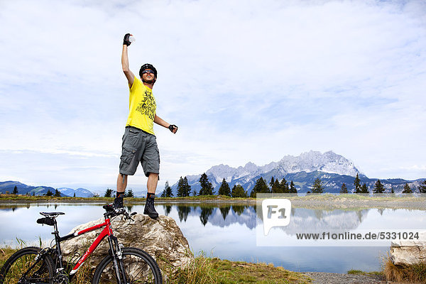 Man with mountainbike posing on rock peak