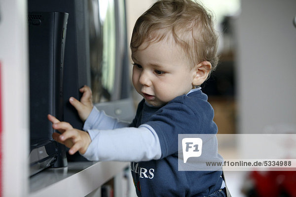 Kleiner Junge 1 Jahr erkundet DVD-Spieler