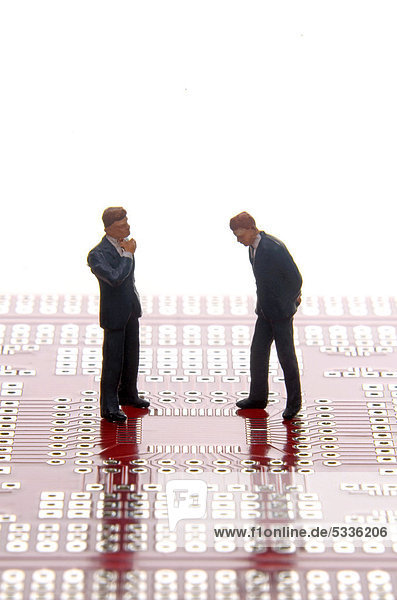 Zwei ratlose Businessmannfiguren auf einer Platine  Symbolbild technische Fehleranalyse
