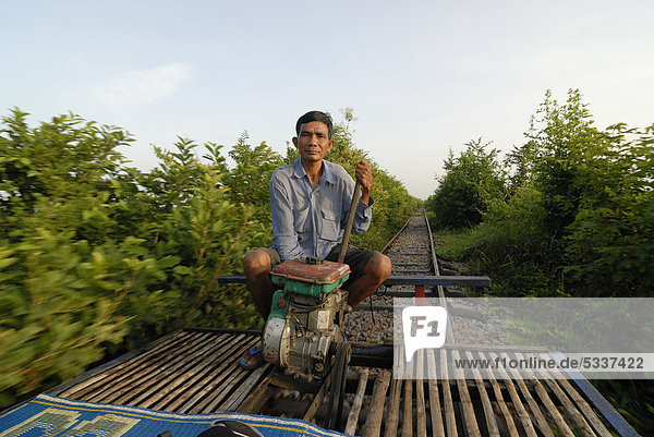 54 year old Khmer man  Cambodian  traveling along the disused railway line of Battambang-Phnom Penh with his home-built bamboo train with a simple drive motor  Battambang  Cambodia  Southeast Asia