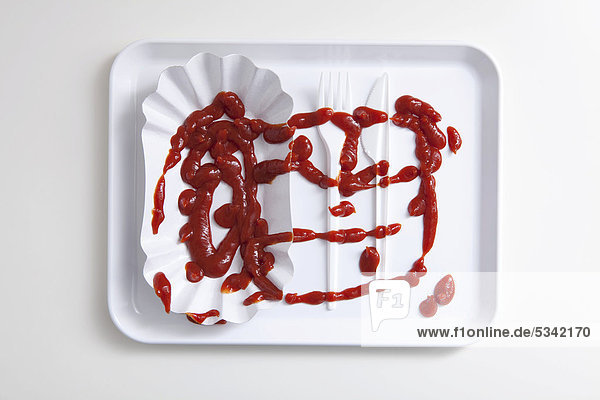 Spilled ketchup on takeaway cutlery and a paper plate