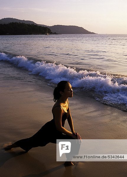 Woman exercising an der Kata Beach Phuket Thailand