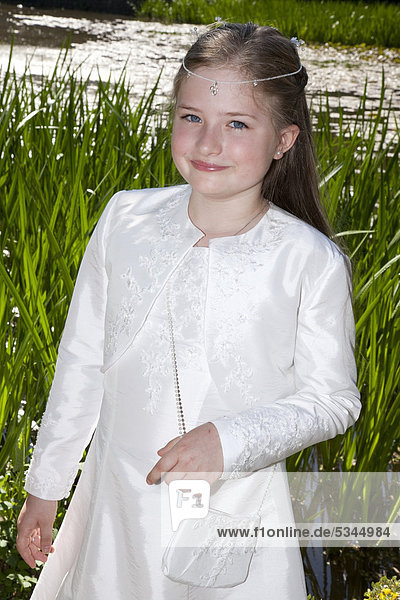 Communicant  girl  9 years  standing at reed grass by a river