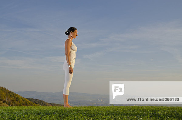 Junge Frau praktiziert Hatha-Yoga im Freien  zeigt die Stellung surya namaskar 1  Sonnengruß 1  Nove Mesto  Okres Teplice  Tschechische Republik  Europa