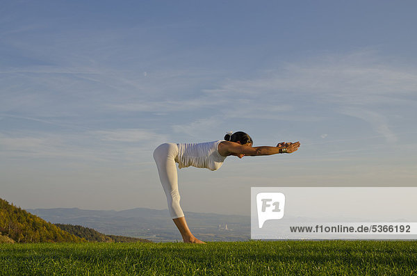 Junge Frau praktiziert Hatha-Yoga im Freien  zeigt die Stellung surya namaskar 13  Sonnengruß 13  Nove Mesto  Okres Teplice  Tschechische Republik  Europa