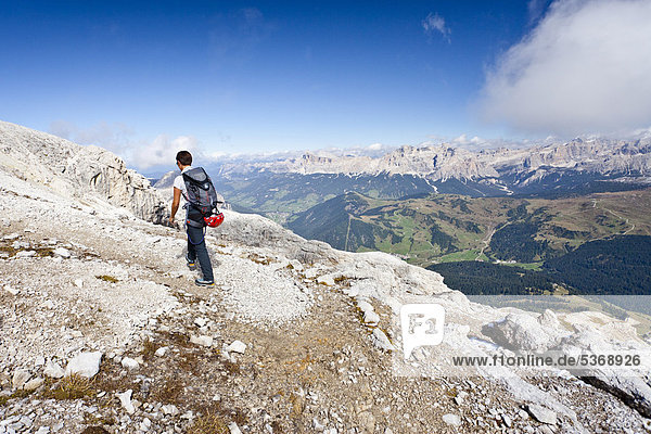 Mountain climber climbing the Boeseekofel Climbing Route  looking towards the Fanes Group and the Heiligkreuzkofel Group  Dolomites  Trentino  Italy  Europe