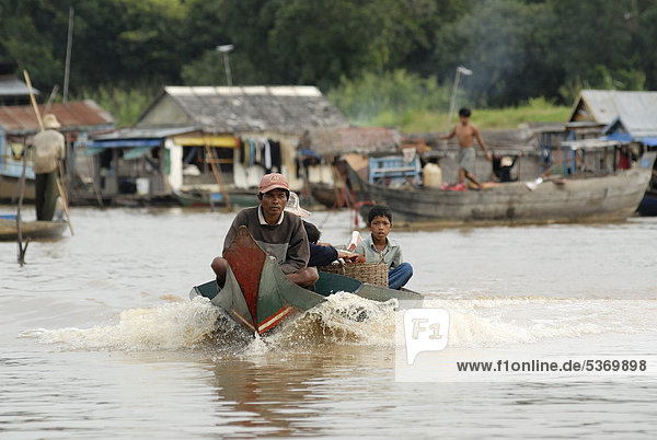 Kambodschanische Bewohner der Schwimmenden Dörfer unterwegs mit einem motorbetriebenen Langboot in voller Fahrt  Chong Khneas  Tonle Sap See  Siem Reap  Kambodscha  Indochina  Südostasien