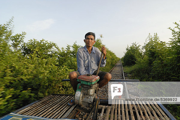 Khmer man  54  Cambodian  travelling along the disused railway line from Battambang-Phnom Penh with his home-built bamboo train with a simple motor  Battambang  Cambodia  Southeast Asia  Asia