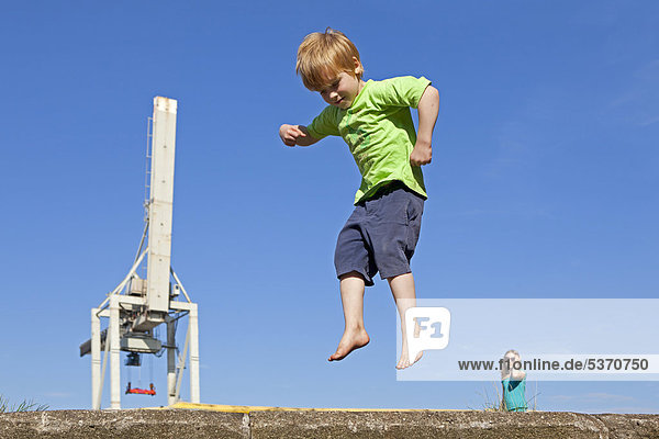 Kleiner Junge springt im Hafen  Hamburg Wilhelmsburg  Deutschland  Europa