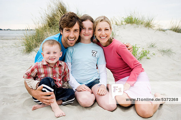 Junge Familie am Strand sitzend  Portrait