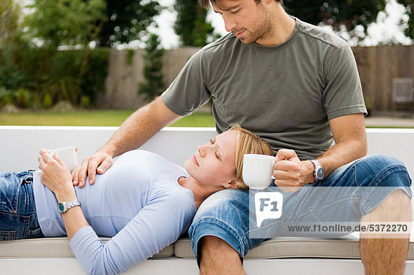Young Couple relaxing outdoors mit Kaffee