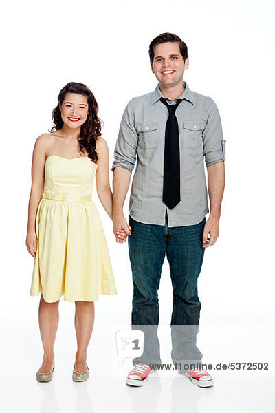 Young couple standing against white background