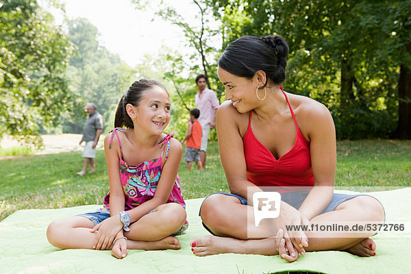 Mutter und Tochter auf Picknickdecke im park