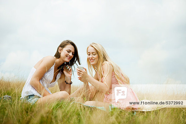 Young women looking at a hand held device together