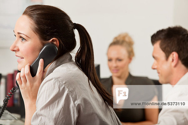 Female employee using a telephone in the office