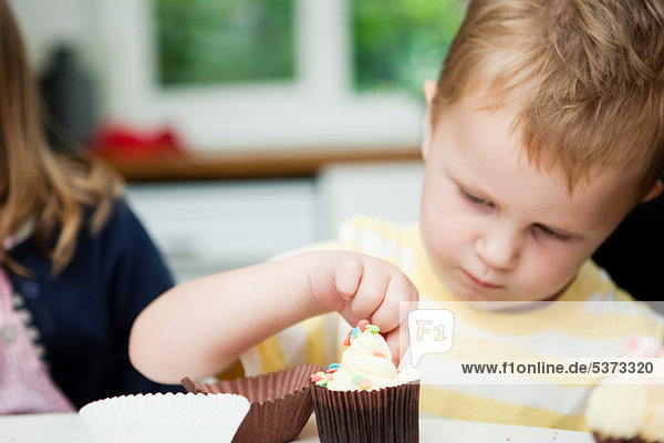 Young boy decorating cupcakes