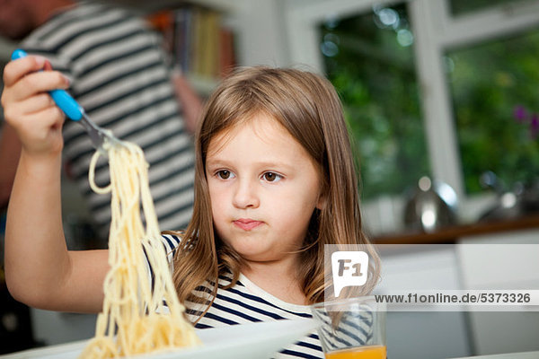 Mädchen mit Spaghetti am Tisch