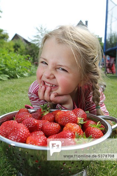 Ein Mädchen mit Erdbeeren in einer Schale
