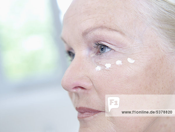 Seniorin mit Gesichtscreme im Gesicht  Nahaufnahme
