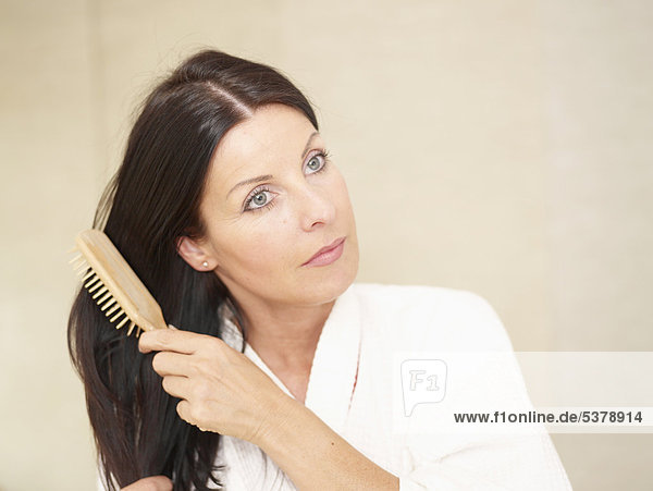 Mature woman using hair brush