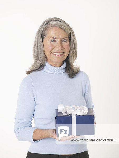 Seniorin mit Geschenkbox  Portrait  lächelnd