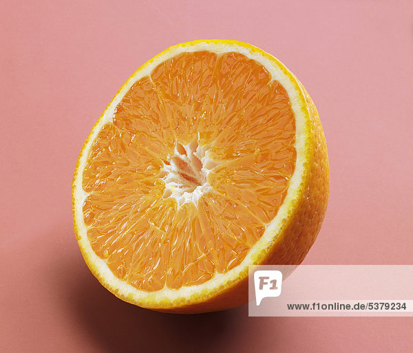 Half cut orange on pink background