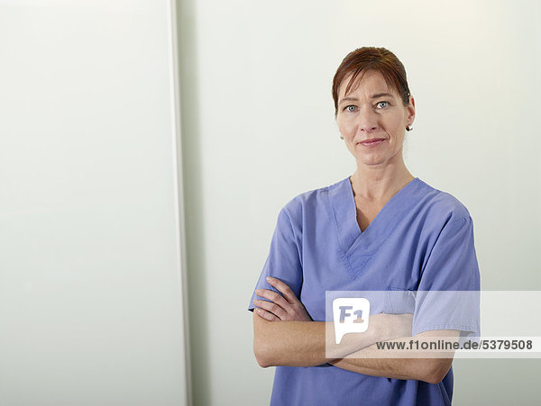Germany  Hamburg  Female doctor in scrubs with arms crossed  portrait