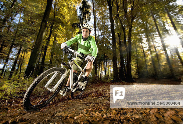Young man mountainbiking in forest