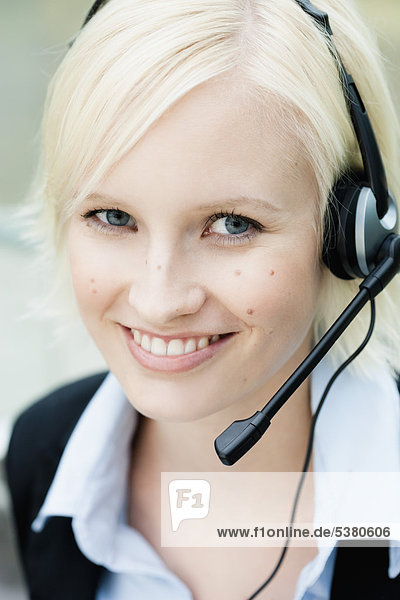Young woman with headset  smiling  portrait