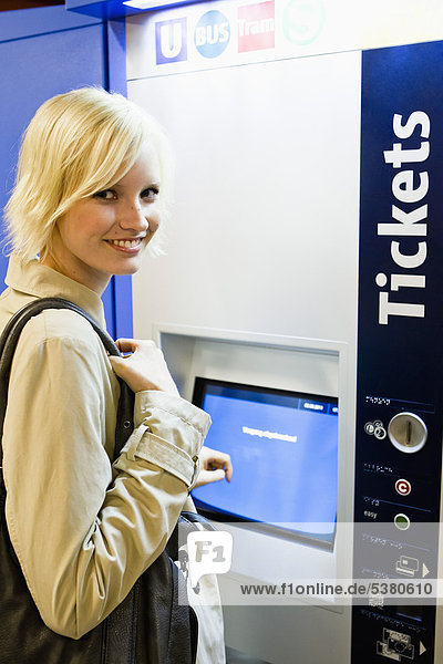 Young woman at ticket machine in metro station