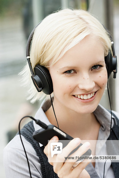 Young woman listening music  smiling  portrait
