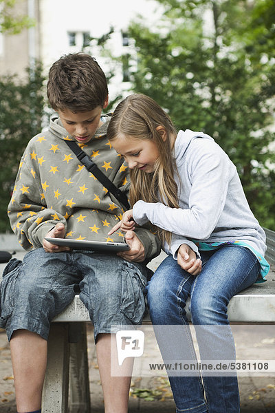 Boy and girl using digital tablet