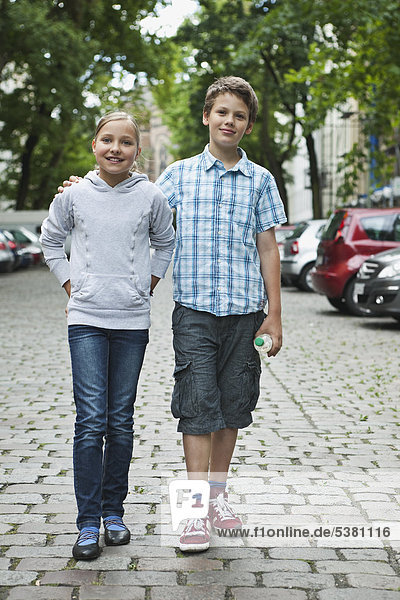 Boy and girl walking in street as couple