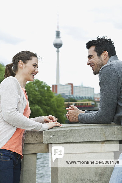 Germany  Berlin  Couple standing on bridge and talking