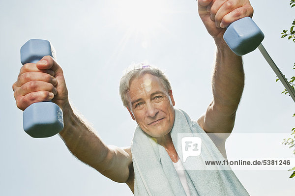 Mature man doing exercise with dumbbells