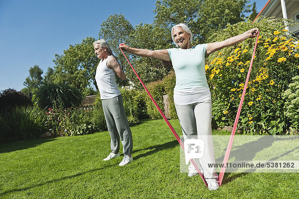 Mann und Frau trainieren im Garten  lächelnd