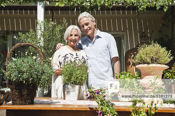 Mann und Frau mit Topfpflanzen  lächelnd  Portrait