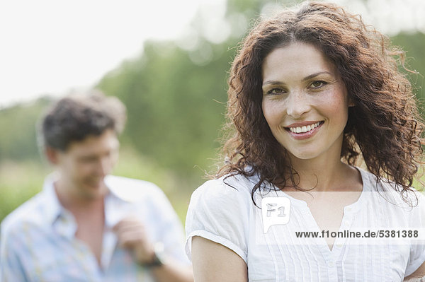 Woman smiling with man in background