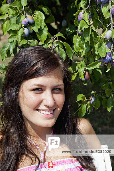 Frau lächelt bei Obstbaum