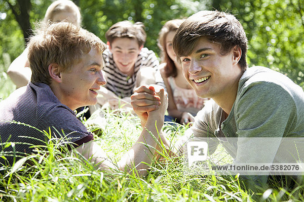 Teenager Jungen Armdrücken im Gras