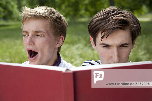 Teenager Jungen beim Lesen im Park