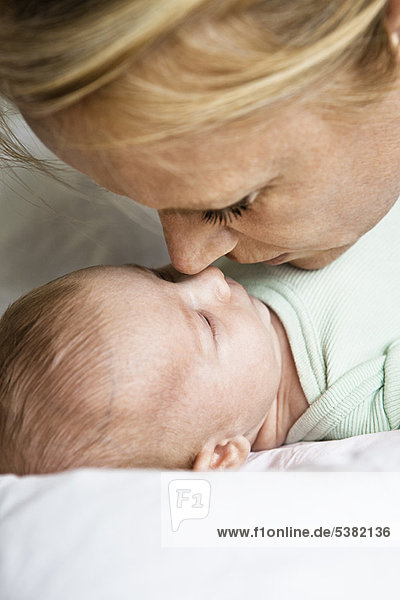Mother touching noses with infant