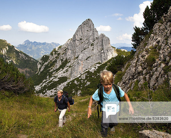 Father and son hiking on mountain path