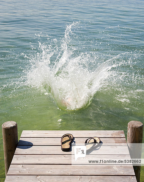 Flip flops on wooden deck by lake