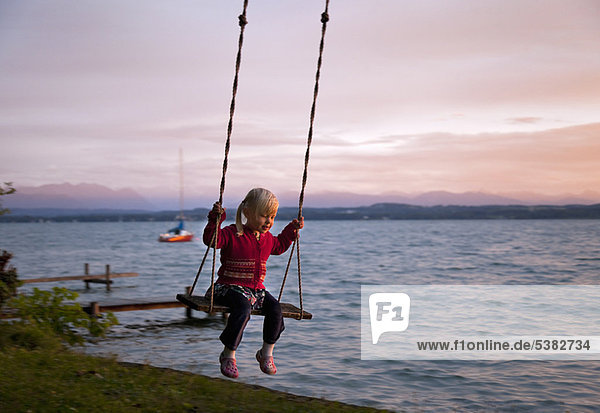 Girl swinging by lake