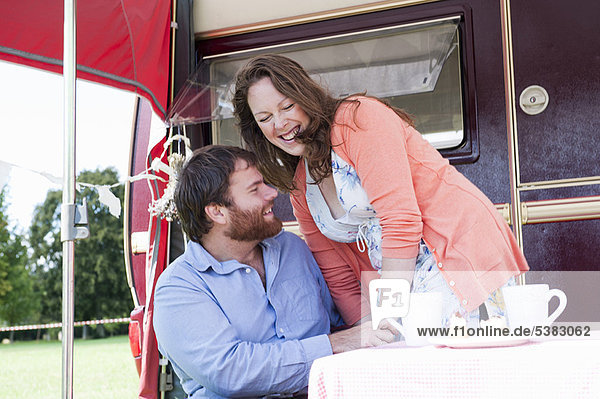 Couple picnicking outside trailer