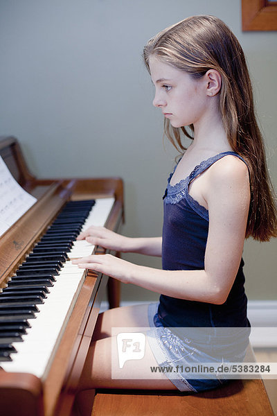 Girl practicing piano indoors