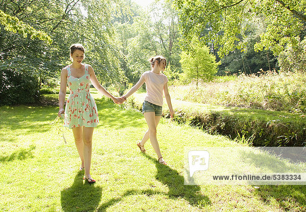 Girls walking together by river
